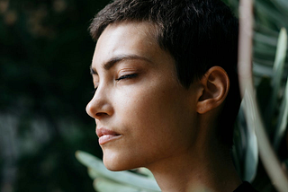 A short haired woman with eyes closed
