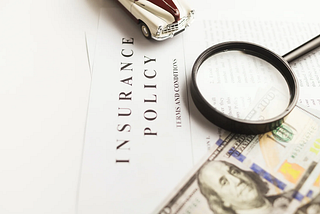 magnifier glass, dollar bill and insurance policy