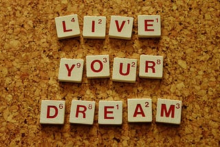 The saying ‘live your dream’ spelled out with Scrabble tiles.