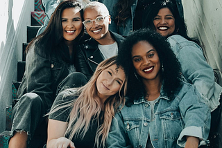 A group of lesbians sitting on steps and smiling