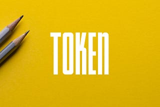 The Token logo on top of a photo of two gray pencils on a yellow background.
