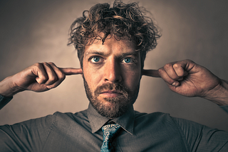 A man plugging his ears.