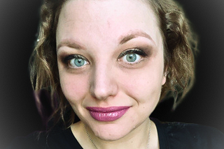 Headshot of Arwyn, white woman, with black background.