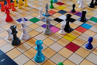 The White King checkmated by a Slate Queen and surrounded by Cyan, Ash, and Black Queens.