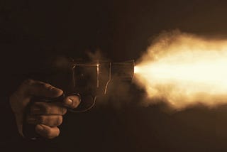 A revolver being fired in the dark.