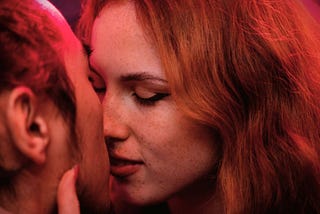 A woman kissing a man