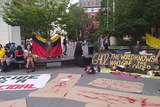 Protestors in Washington Square Park. Posters with fake blood and “6,402: the world knows who gave the order”