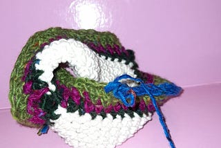 An indescribable crocheted object, with different colours defining concentric rows of a twisted 5 D base
