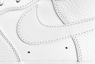 A close up profile crop of a Nike Air Force 1 shoe in all white
