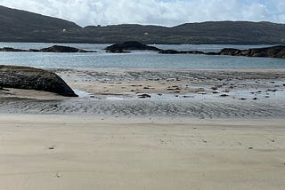 scene at Derrynane beach overlooking peninsulas and rocks.