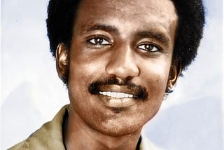 Portrait photo of a young, smiling Black man.