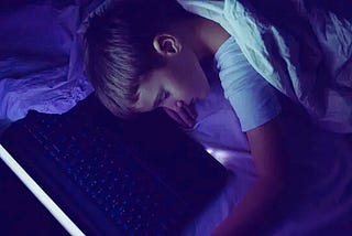Child fallen asleep next to parent’s laptop