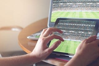 A Laptop and ipad showing synchronized sports streaming