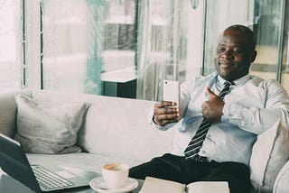 A man in a tie giving a thumb’s up to a phone. You only need to prove yourself to yourself