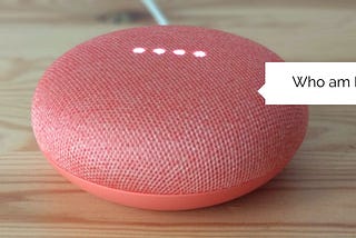 Pink Google Home Mini with a speech bubble saying “Who am I?”