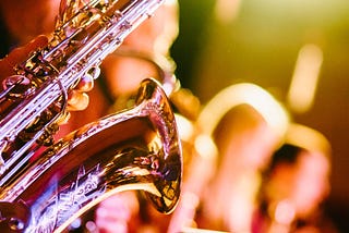 Saxophone player and backing vocal singers — Photo by Jens Thekkeveettil on Unsplash
