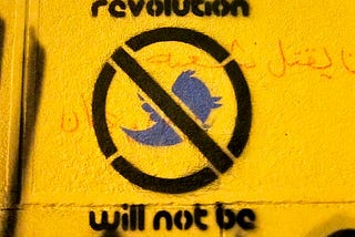 Street art saying “the revolution will not be tweeted” with a Twitter bird with a line through it