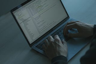 Person typing code on his MacBook