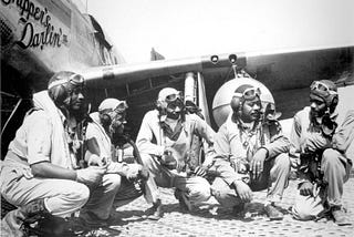 Five Tuskegee Airmen pilots in front of an airplane wing in 1942. Photo from U.S. Air Force.