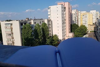 Buildings in the background and an open notebook up front