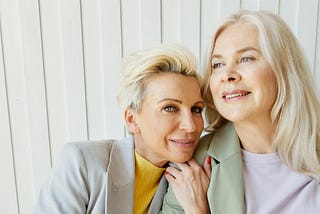 Two middle aged women posing together as friends