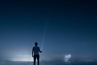 A person looking into the starry sky at night