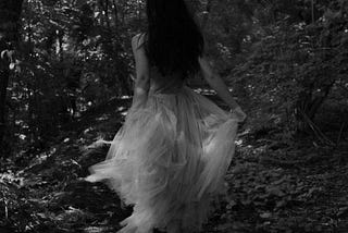 She s running through the woods dressed in a black silk gown with a hood in it , and a dragon…