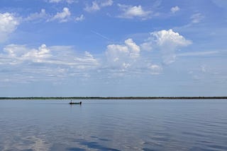 A lone fishing boat sits in the vast surrounding waters of Lake Jesup, Florida
