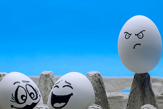 two eggs having fun while one is envious