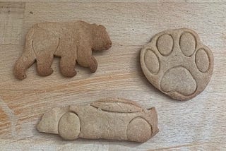 Three ginger biscuits in the shape of a bear, a paw print, and a racing car