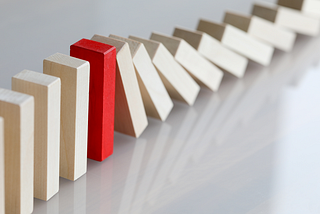 wooden dominoes shown in the midst of falling.