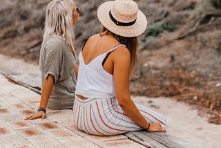 a blonde woman and a brunette sitting