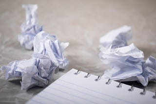 Notebook of paper with crumpled balls of paper