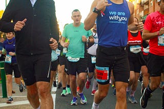 Harry, wearing a WeAreWithYou vest, running in a marathon.