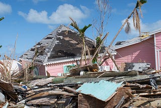 In The Bahamas a pink house and a pile of construction rubble stands in ruin after being hit by hurricane Dorian.