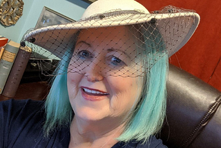 Elaine Lindsay in office in a hat — what you can’t see from a quick glance