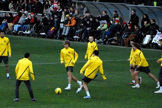 Barcelona players in yellow training tops warming up in a rondo