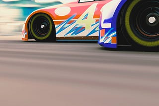 The front end of two stock cars racing with a number 4 car in the lead