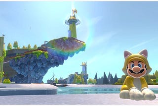 Mario sits (right) dressed in a yellow cat power up suit in front of a body of water. A piece of land juts up into the sky featuring a lighthouse (left), with more Mario level geometry on the horizon.