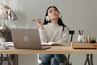 Young woman in front of laptop deep in thought