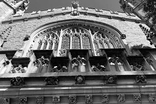 University chapel with arched stained-glass window and gargoyles. (Photo by author.)