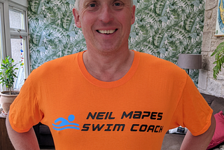 Neil Mapes the author in a bright orange swim coach t shrt