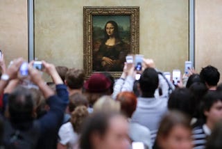 Visitors crowd in front of Leonardo da Vinci’s painting Mona Lisa at The Louvre in Paris.