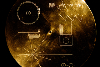 Upscaled image of NASA’s Voyager Golden Record cover, showing a circular gold disc engraved with symbolic diagrams for playback, image decoding, a pulsar map, and a hydrogen atom reference, set against a black background.