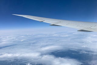 The view out the window of the plane flying above the clouds