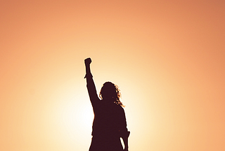 Silhouette of a person with their arm raised in a fist