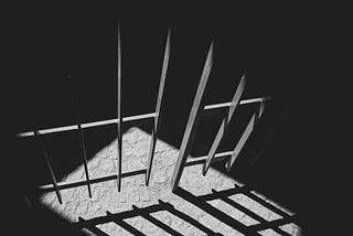 Black and white photo of prison bars.