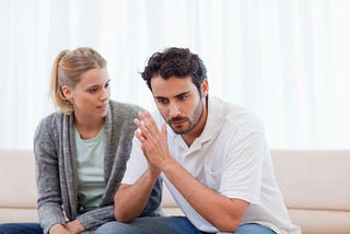 man and woman sitting on couch in deep conversation