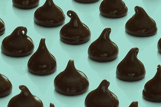 Chocolate chips arranged in rows on a green background
