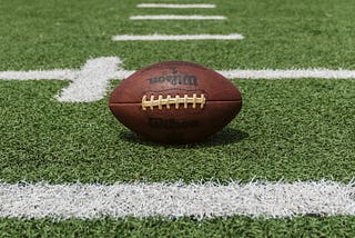 American Football laying on the field.